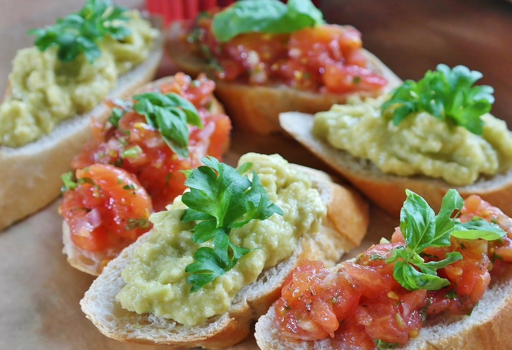 Guacamole in mexico served on toasted bread with fresh tomato topping, a simple street style snack inspired by travel food experiences