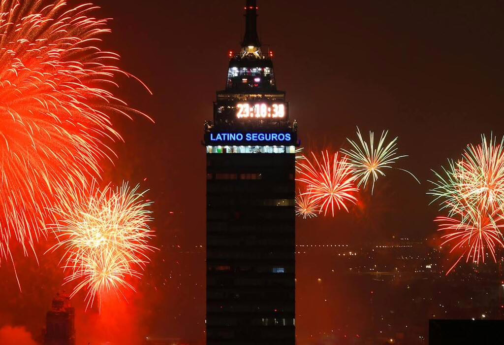 Torre Latinoamericana in Mexico City with bright New Year’s Eve fireworks lighting the night sky.