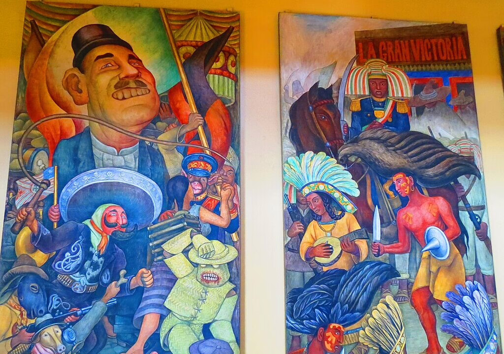 Colorful Mexican mural by Diego Rivera showing historical figures, indigenous people, and revolution scenes at Palacio de Bellas Artes