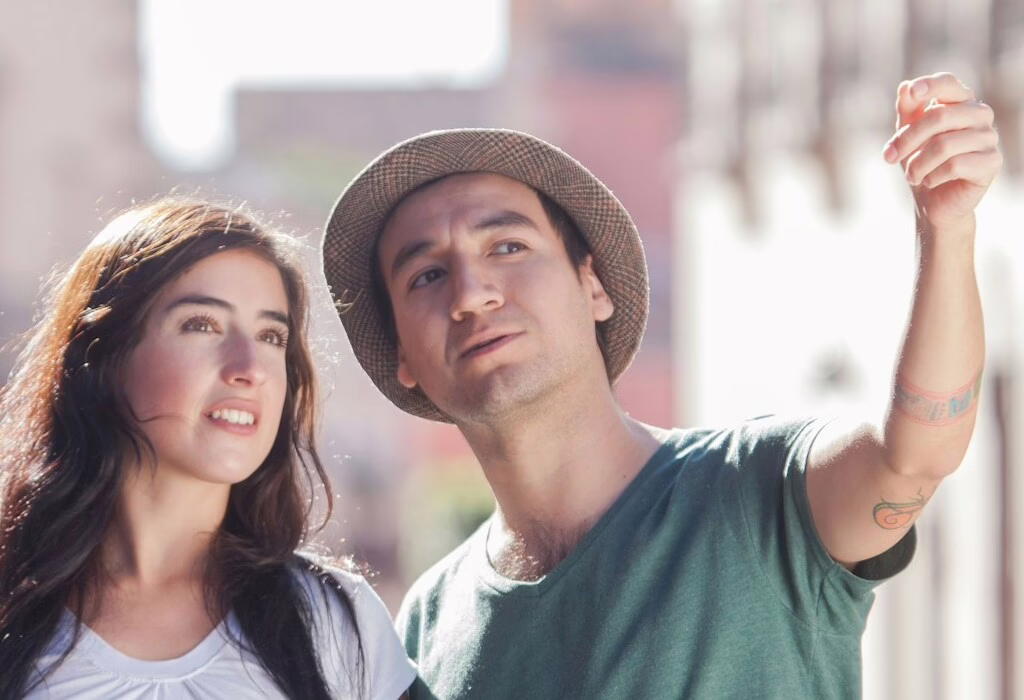 A couple exploring a charming city street, enjoying a walking tour with a guide pointing out landmarks.