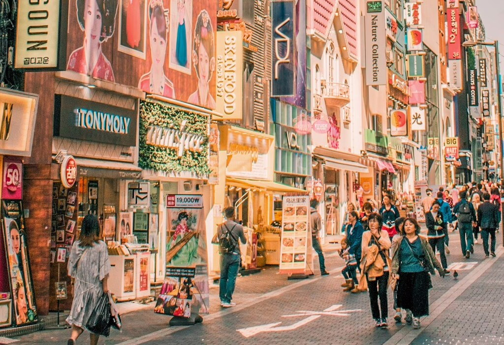 Colorful street in South Korea with vibrant signs and people walking.