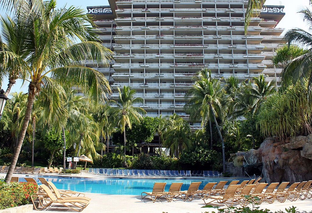 A beachfront hotel in Acapulco surrounded by palm trees, offering a perfect blend of comfort and natural beauty.