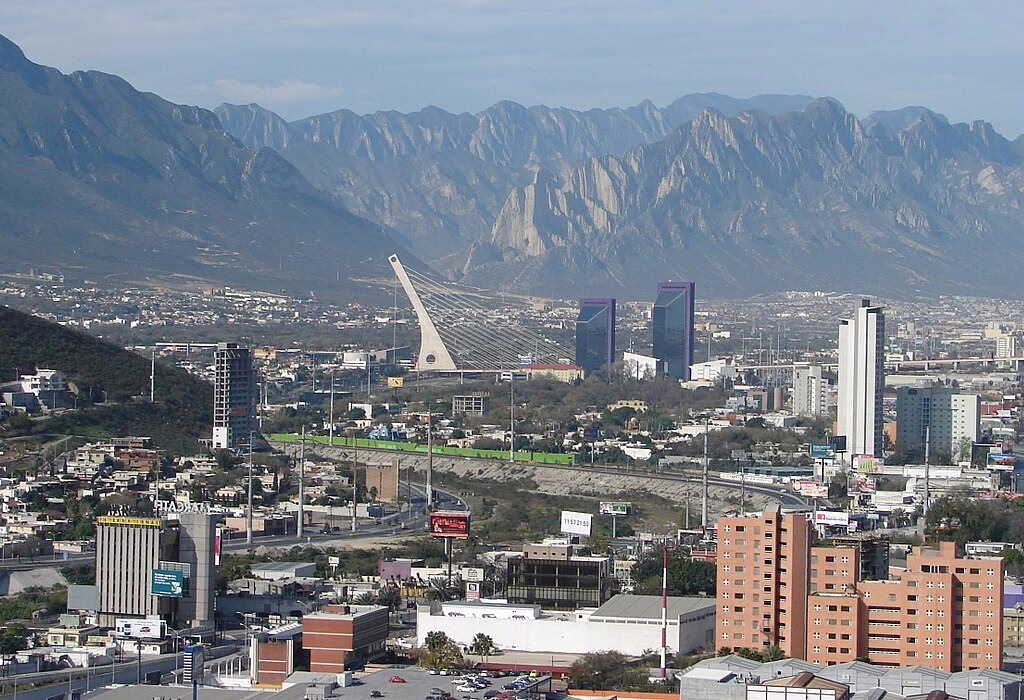 Vista panorâmica da cidade de Monterrey com montanhas e horizonte moderno, símbolo do norte do México.