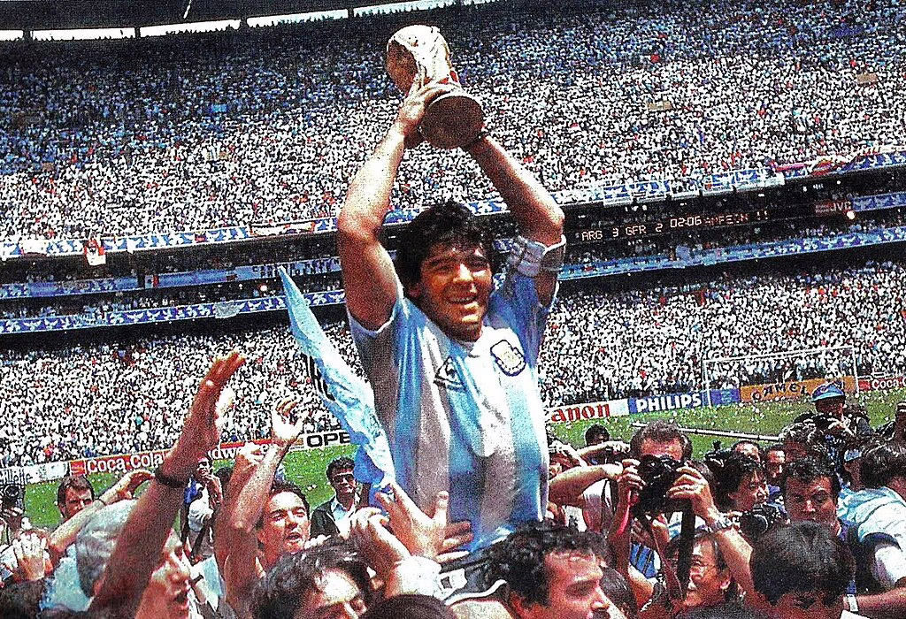 Diego Maradona segurando o troféu durante uma copa do mundo anterior no México, no Estádio Azteca.