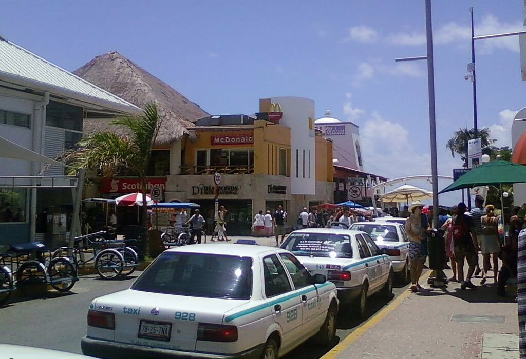 Busy tourist street in Playa del Carmen with authorized taxis and shops, part of one of the safest destinations in Mexico