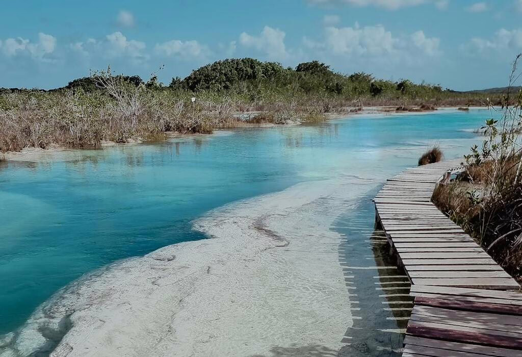 Wooden boardwalk along the turquoise waters of Bacalar Lagoon, a calm and safe nature destination in Mexico