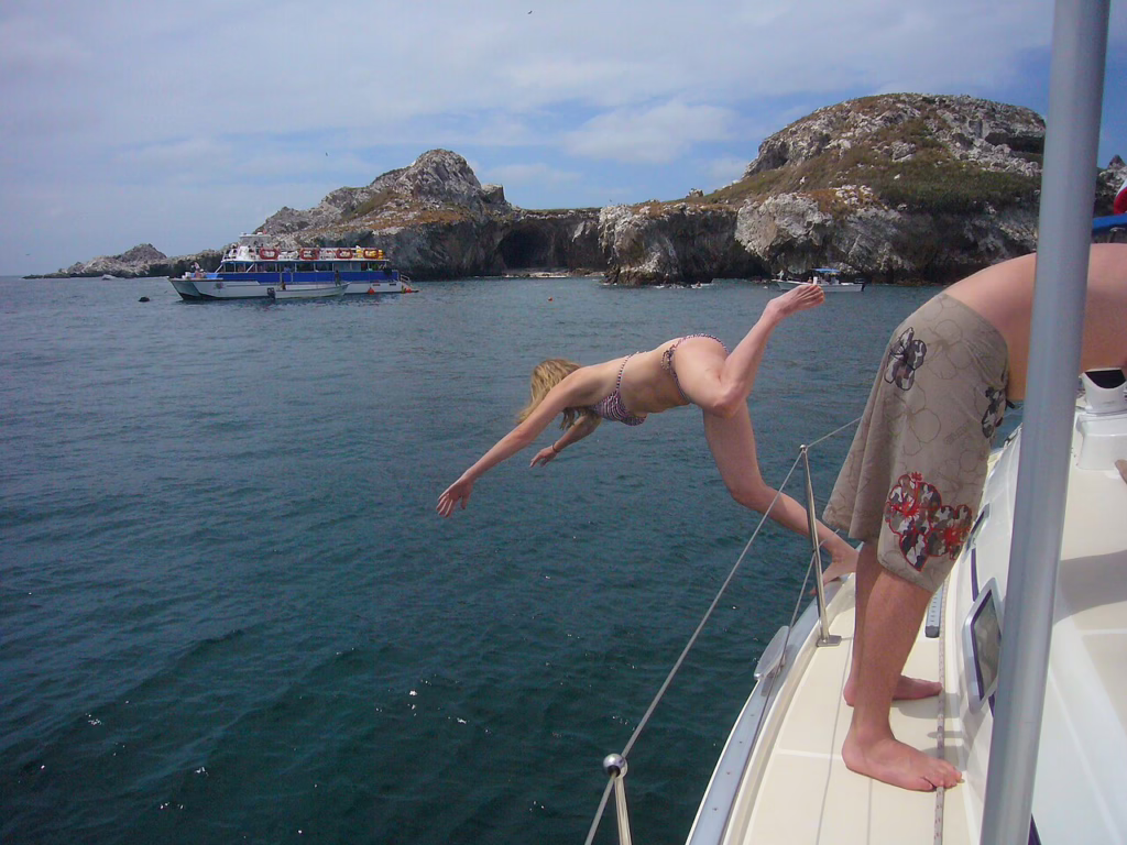 Traveler diving from a boat into the ocean near Marietas Island during a guided tour from Puerto Vallarta