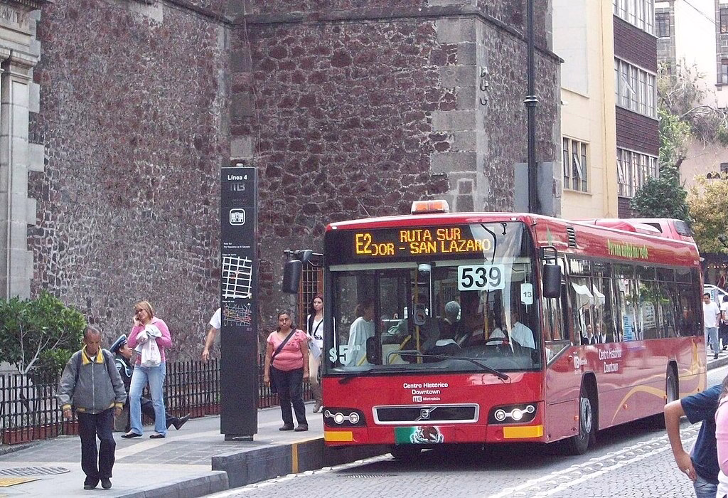 A red Metrobus (Line 4) at a stop in downtown. Using Mexico City's efficient public transport is essential for connecting hostels in mexico city and accommodation mexico city airport to the World Cup stadium while saving money