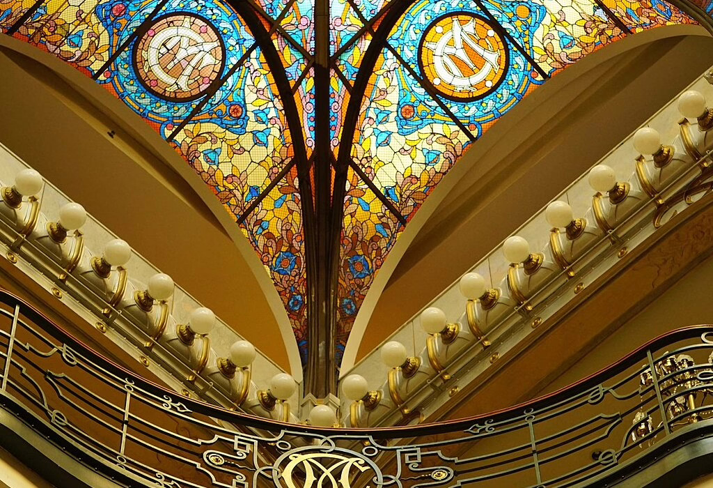 A beautiful ceiling made of colorful stained glass with blue, yellow, and red patterns. It is inside the Gran Hotel Ciudad de Mexico in the historic center.