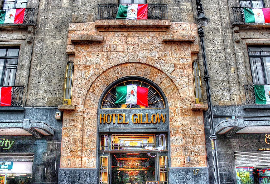 Stone facade of Hotel Gillow with Mexican flags. A reliable option for affordable hotels in Mexico City near the Zocalo for World Cup fans.