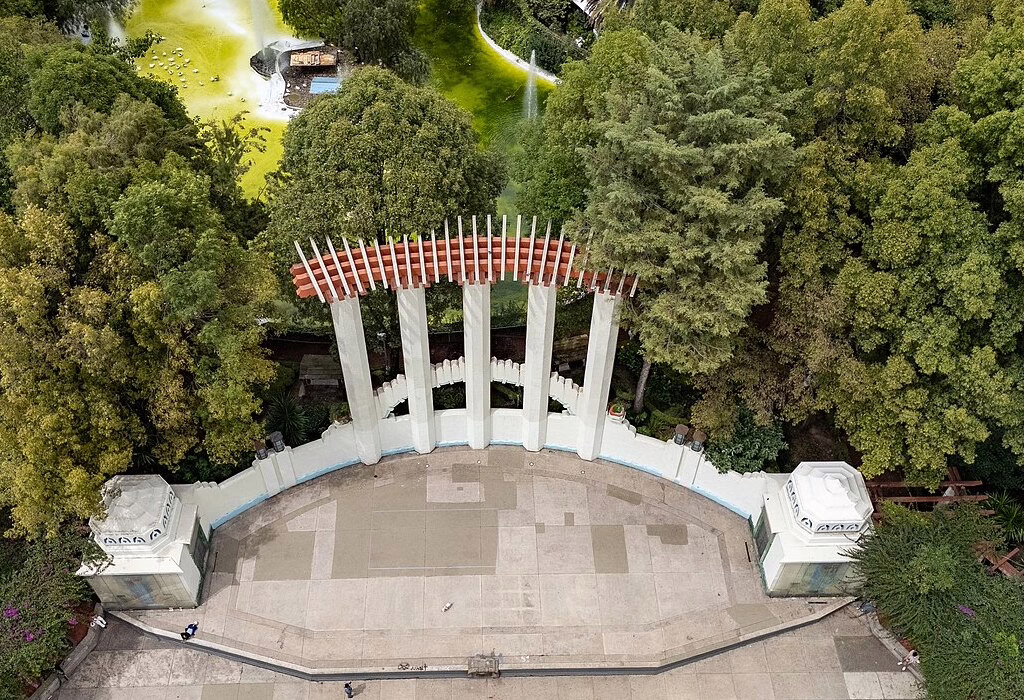 Aerial view of Parque Mexico in the Condesa neighborhood. A green park surrounded by trees and Art Deco architecture where football fans gather.