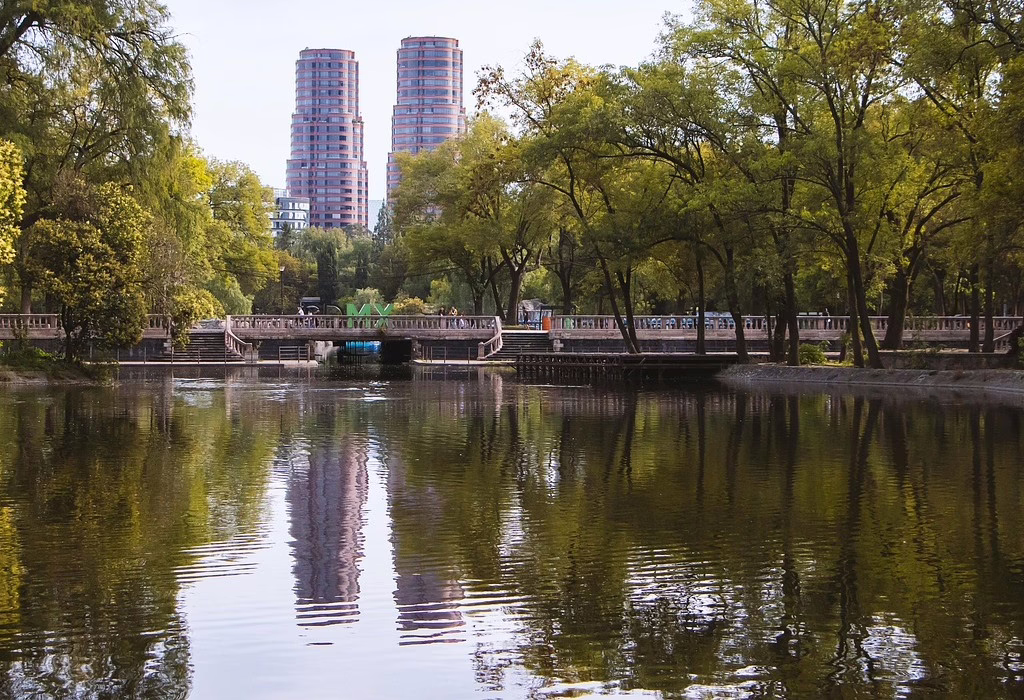 Chapultepec Park lake in Mexico City with the famous skyscrapers in the background. A large green space that hosts the FIFA Fan Festival for World Cup matches.