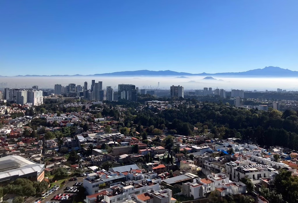 Panoramablick auf die Skyline von Mexiko-Stadt und die Berge, mit Blick auf preisgünstige Regionen für billige Reisen nach Mexiko.